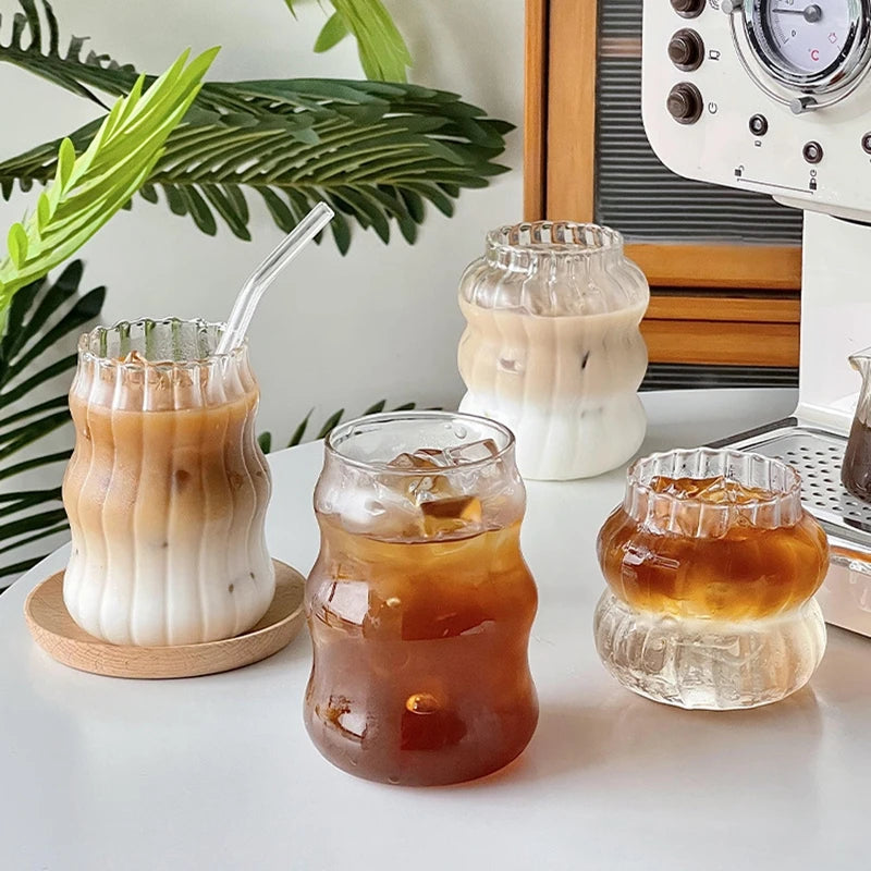 Verre Tumbler Ondulé Transparent – Élégant & Pratique. Quatre verres ondulés en verre transparent avec cafés glacés