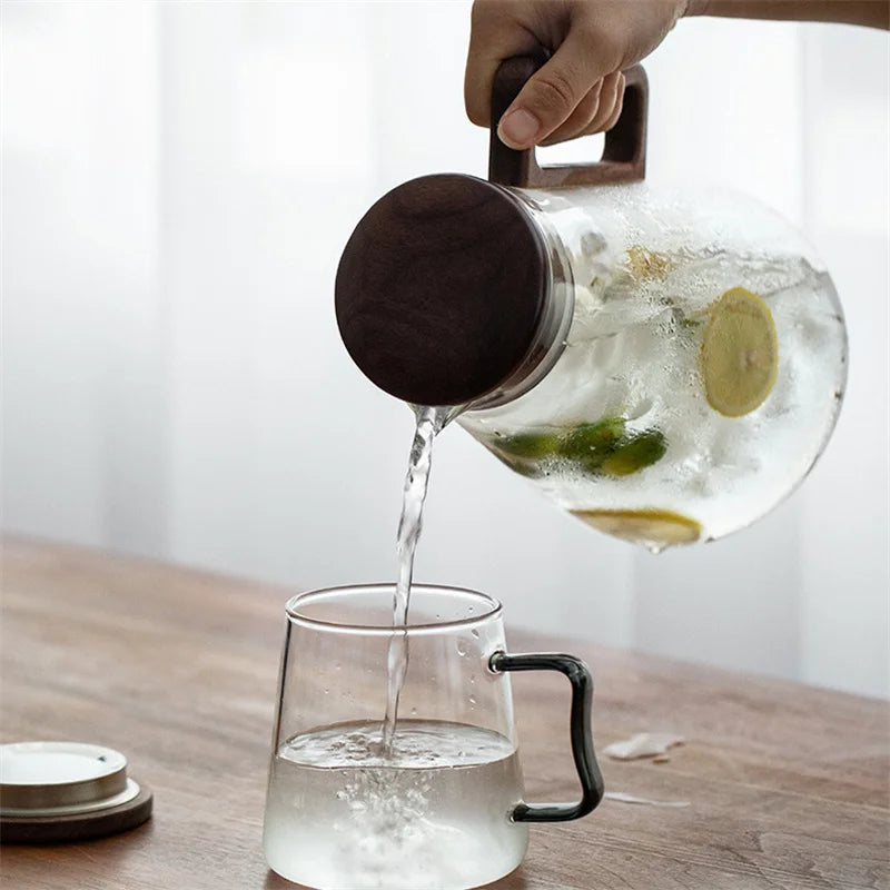 Carafe en Verre 2 L BenRussell Infuseur et Bouchon Filtrant versant une boisson rafraîchissante dans un verre