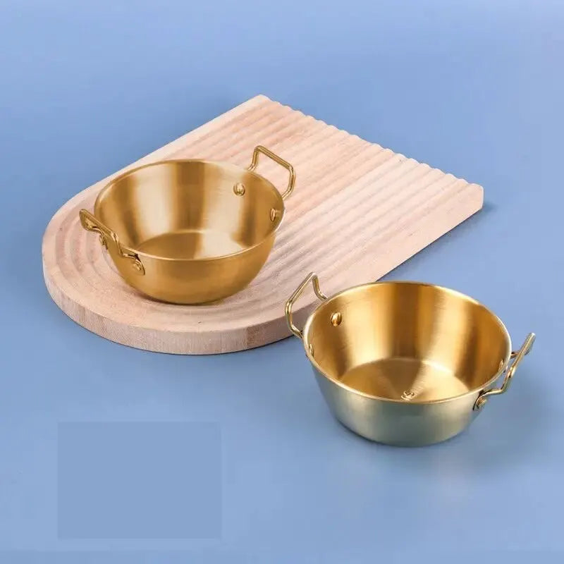 Bol Inox Doré avec Anse Anti brûlure – 12 à 14 cm posé sur surface bleue avec plateau en bois