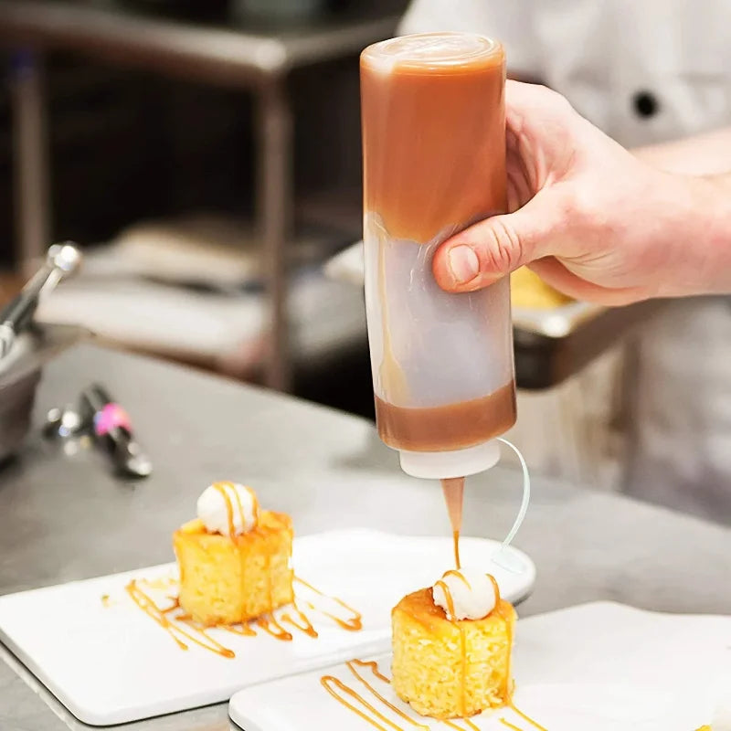 Bouteilles à Sauce Réutilisables – Cuisine Propre et Écolo utilisées pour décorer des desserts dans une cuisine professionnelle