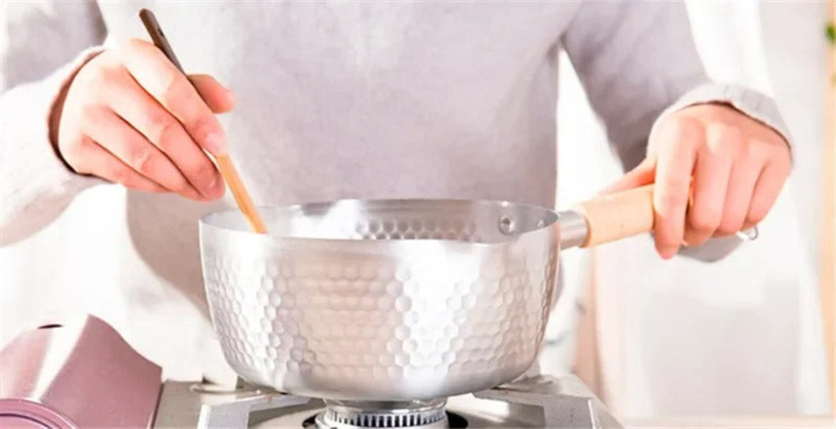 Casserole antiadhésive aluminium en action sur une cuisinière, compatible induction et gaz