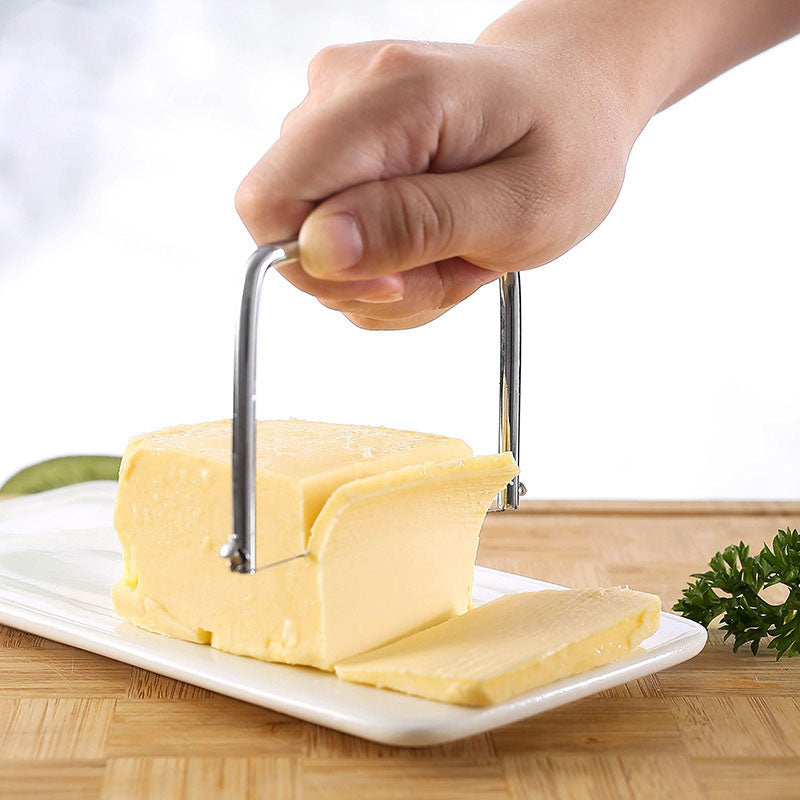Coupe-fromage et beurre inox – Tranches fines et régulières utilisé pour trancher du beurre sur une assiette blanche