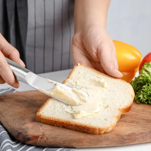 Couteau à Beurre Inox 304 – Spatule Tartineur Éco étalant du beurre sur une tranche de pain