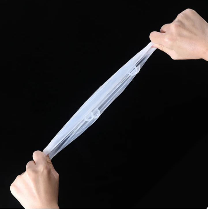 Set 6 couvercles silicone extensibles – Conservation facile. Deux mains étirent un couvercle montrant élasticité et adhérence
