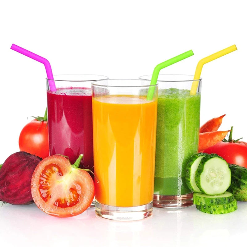 Pailles Réutilisables en Silicone – Lot de 2 avec Brosse. Trois verres de jus colorés avec pailles rose vert jaune.