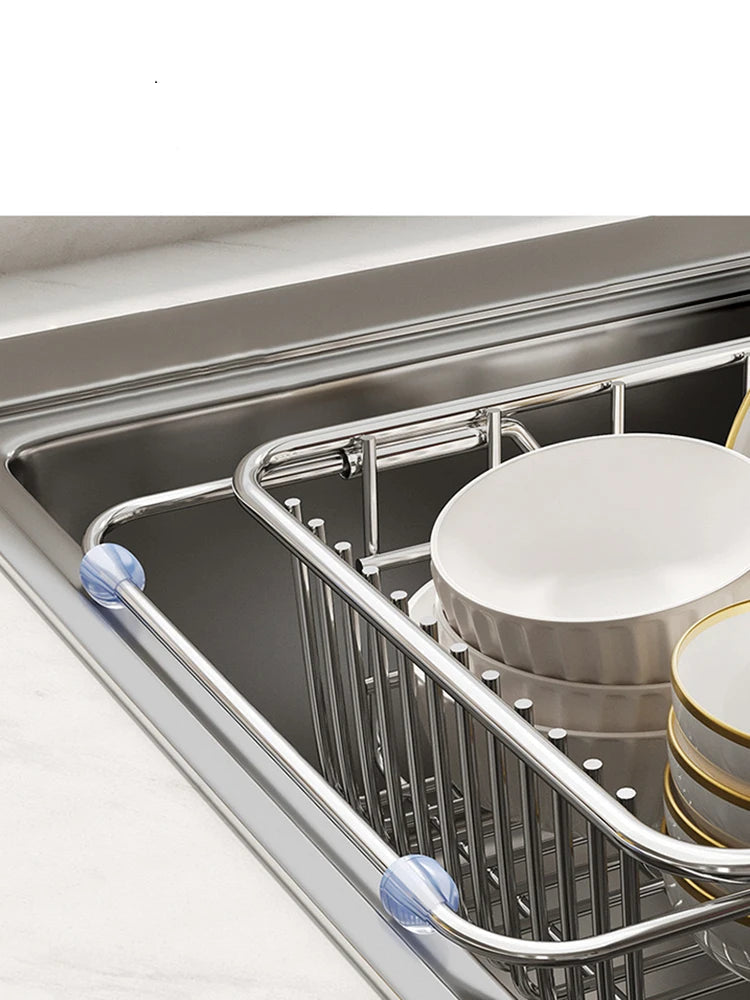 Égouttoir à Vaisselle Extensible Inox en acier inoxydable installé dans un évier avec vaisselle blanche empilée