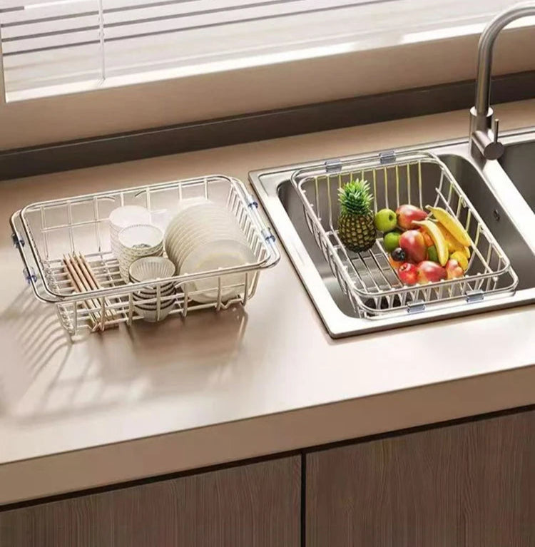 Égouttoir à Vaisselle Extensible Inox posé sur un plan de travail avec vaisselle et fruits