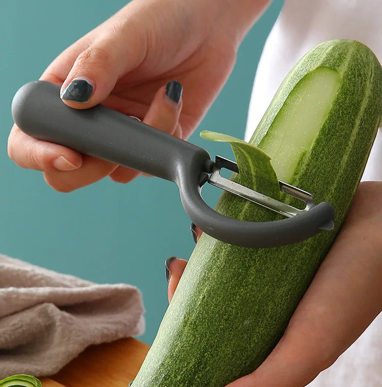 Éplucheur Inox Multifonction – Fruits Légumes Antidérapant utilisé pour peler un concombre frais avec manche ergonomique