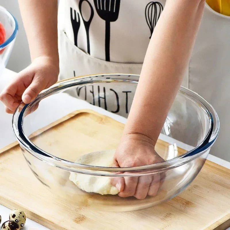 Grand bol en verre transparent pour la préparation de la pâte avec une main pressant la mixture