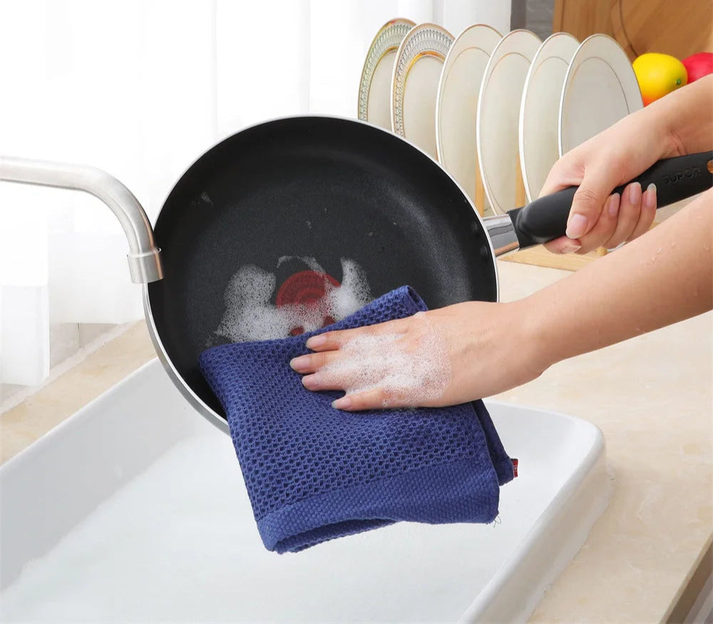 Lot de Torchons Nid d’Abeille – Absorbants & Écologiques essuyant une poêle noire dans une cuisine moderne