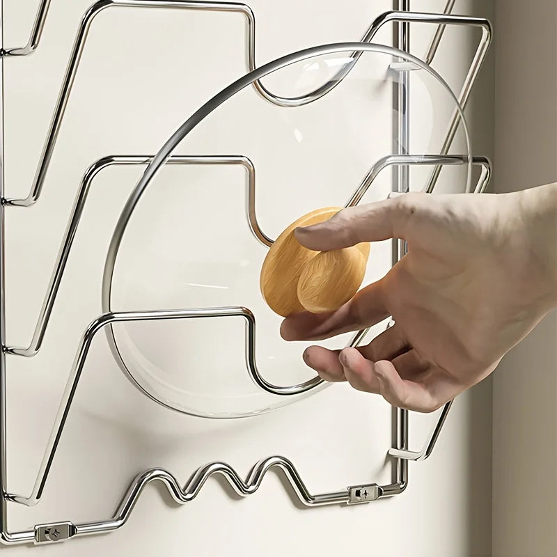 Support mural 5 couches pour couvercles de casseroles. Support chromé montrant une main retirant un couvercle en verre