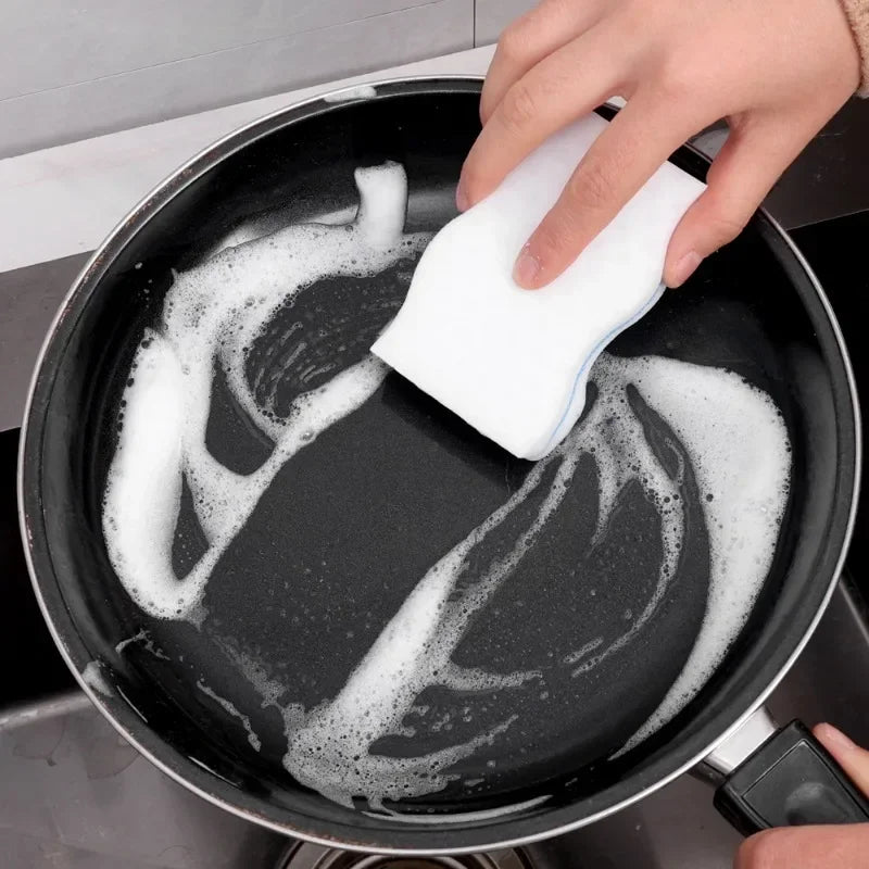 Main essuyant une poêle antiadhésive avec une Éponge magique – Lot de 50 pièces éco-friendly 10×6 cm. blanche et douce
