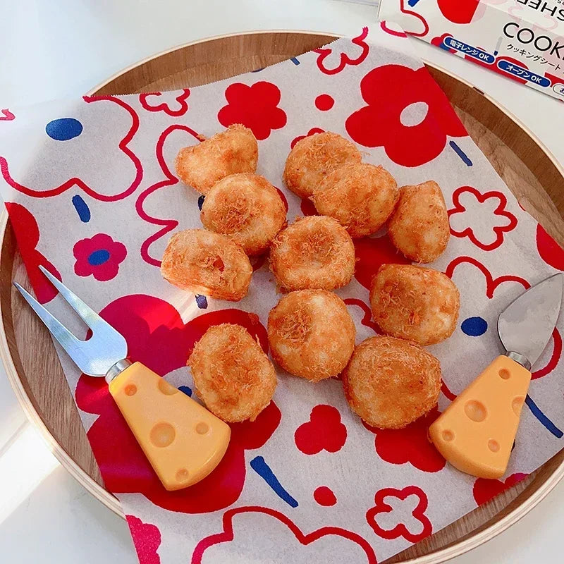 Papier Cuisson Antiadhésif 25 cm avec Découpe Facile sous des beignets dorés sur plateau en bois avec outils à poignée orange