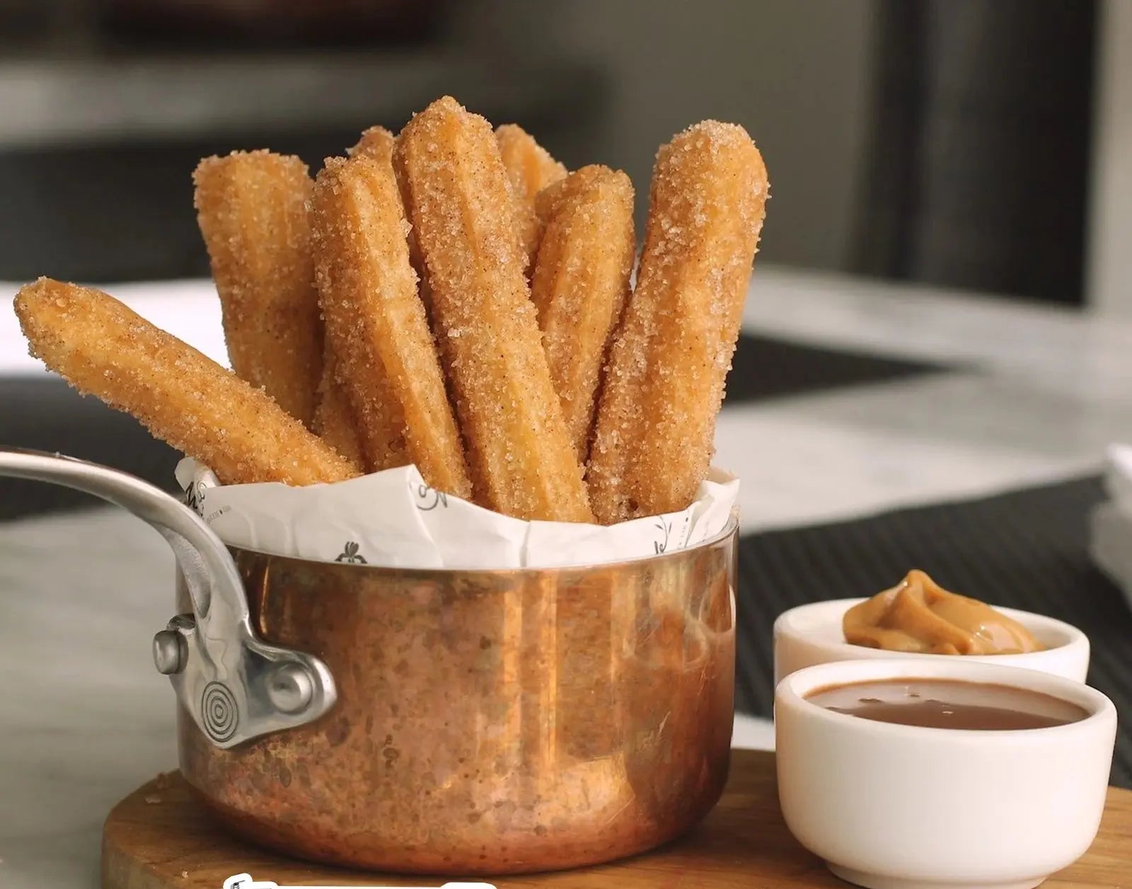 Pistolet à Pâtisserie Inox – Churros & Biscuits Maison Faciles présentés dans un récipient en cuivre avec sauces