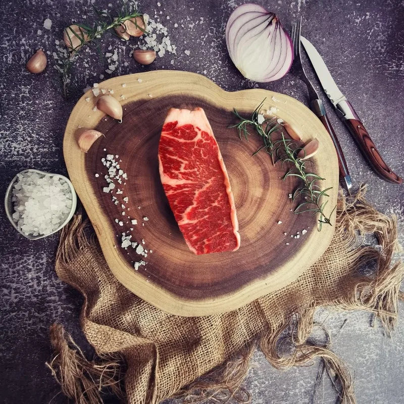 Planche Bois d’Acacia Naturel – Découpe & Présentation avec steak cru, ail, oignon rouge et couteaux