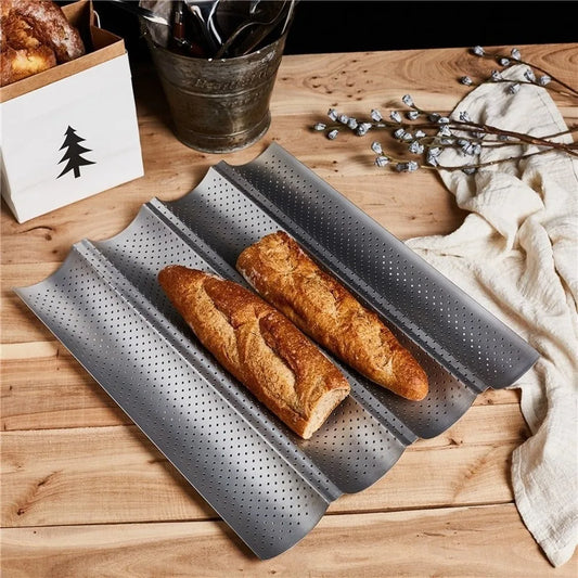 Plaque à Pain – Antiadhésive en Acier Carbon pour Four avec deux baguettes dorées sur une table en bois.