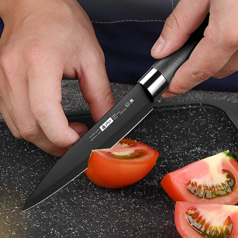 Couteau Cuisine PLYS Lame Noire – Inox Antirouille avec poignée noire coupant une tomate fraîche
