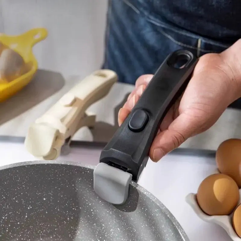 Poignée Amovible Universelle en noir utilisée pour une casserole avec des oeufs à côté