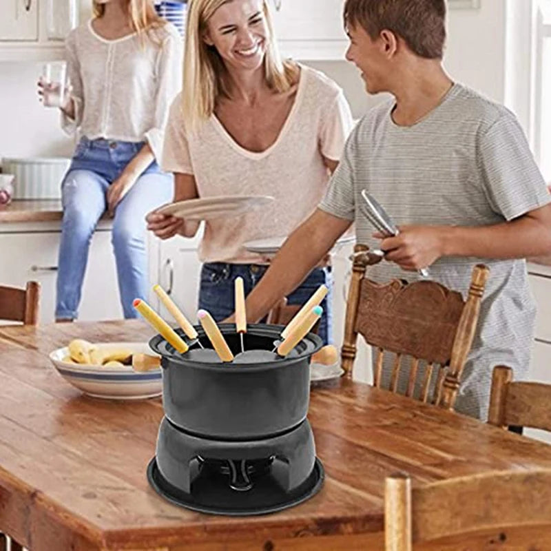 Pot à Fondue Acier Inox Mini – Fromage & Chocolat avec 6 Fourchettes sur une table en bois avec des convives