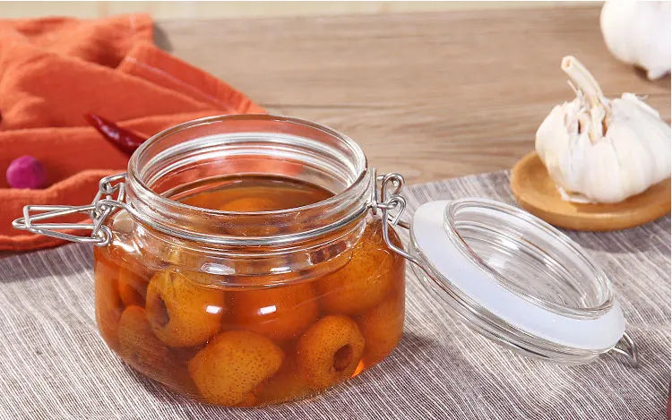 Pot de Rangement Hermétique en Verre avec fruits conservés, couvercle ouvert et fermeture métallique
