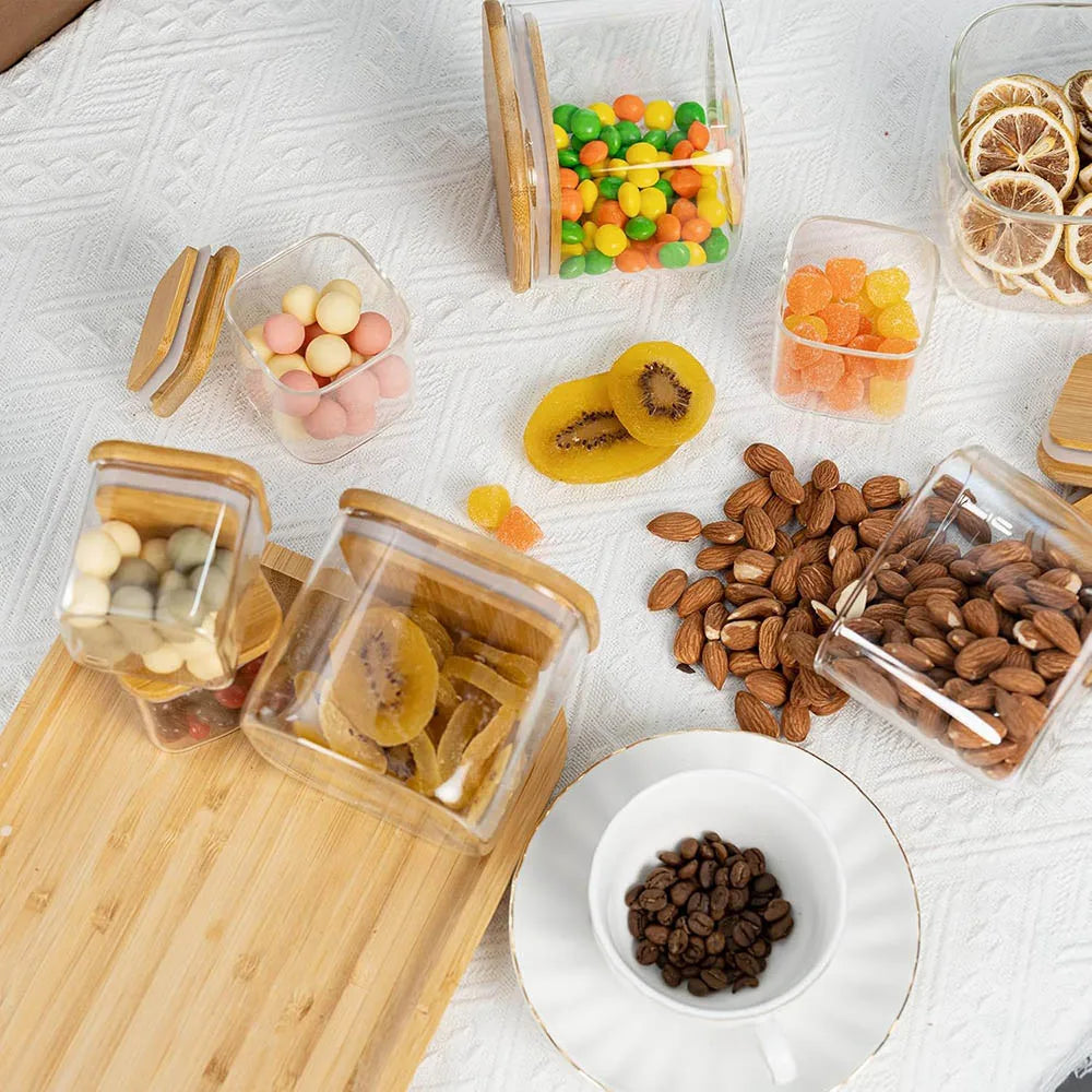 Pots à Épices en Verre avec Couvercles Bambou – 6 à 12 pcs remplis de fruits secs, noix, et bonbons sur table