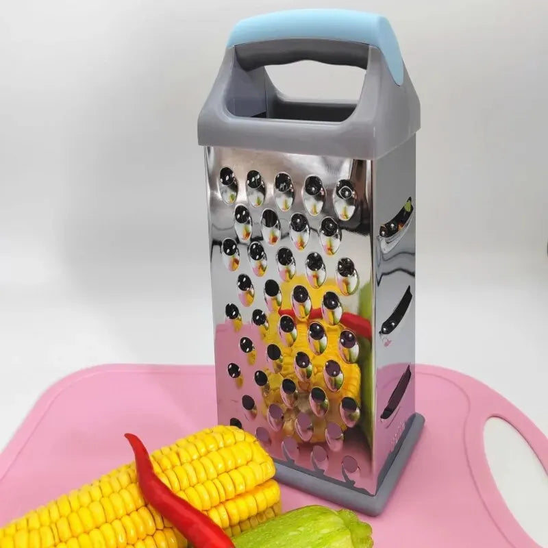 Râpe 4 Faces Inox – Polyvalente, Précise et Durable avec poignée ergonomique posée sur planche rose à côté de légumes