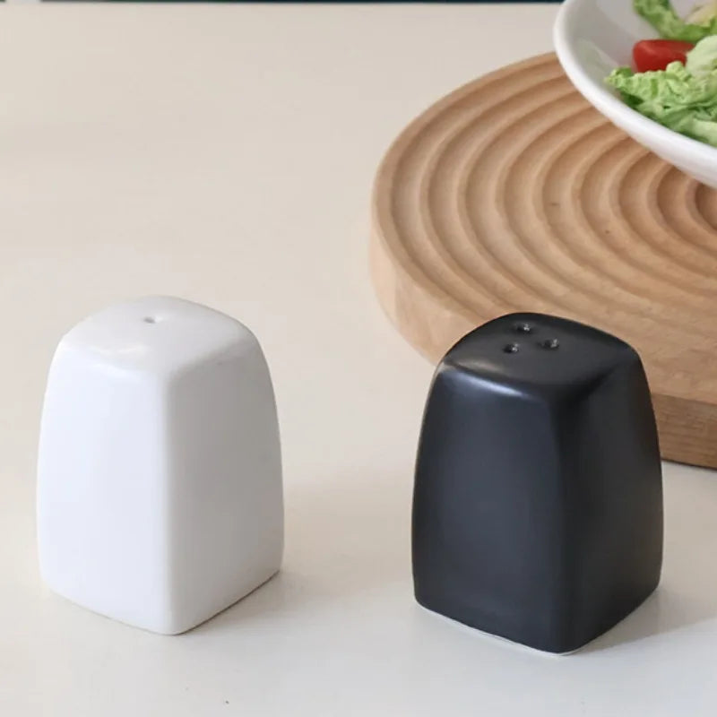 Salière et Poivrière en Céramique – Duo Fait Main Design blanc et noir sur table avec saladier
