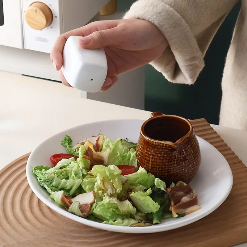 Salière et Poivrière en Céramique – Duo Fait Main Design utilisée pour assaisonner une salade verte fraîche