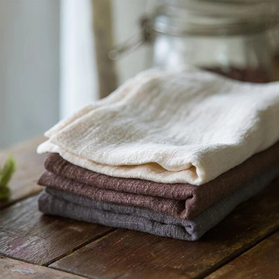 Serviette de Table en Coton 100 % Naturel – Élégante, Réutilisable et Écologique pour Repas Chic, empilées sur une table en bois.
