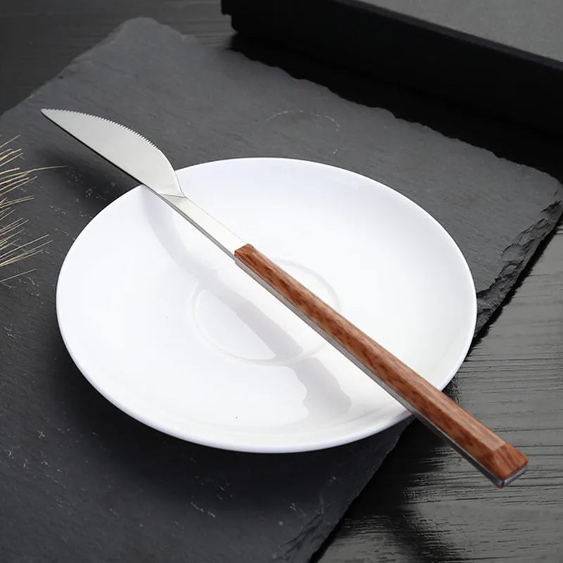 Set Couverts Inox Imitation Bois – Service 16 Pièces Élégant avec un couteau sur une assiette blanche