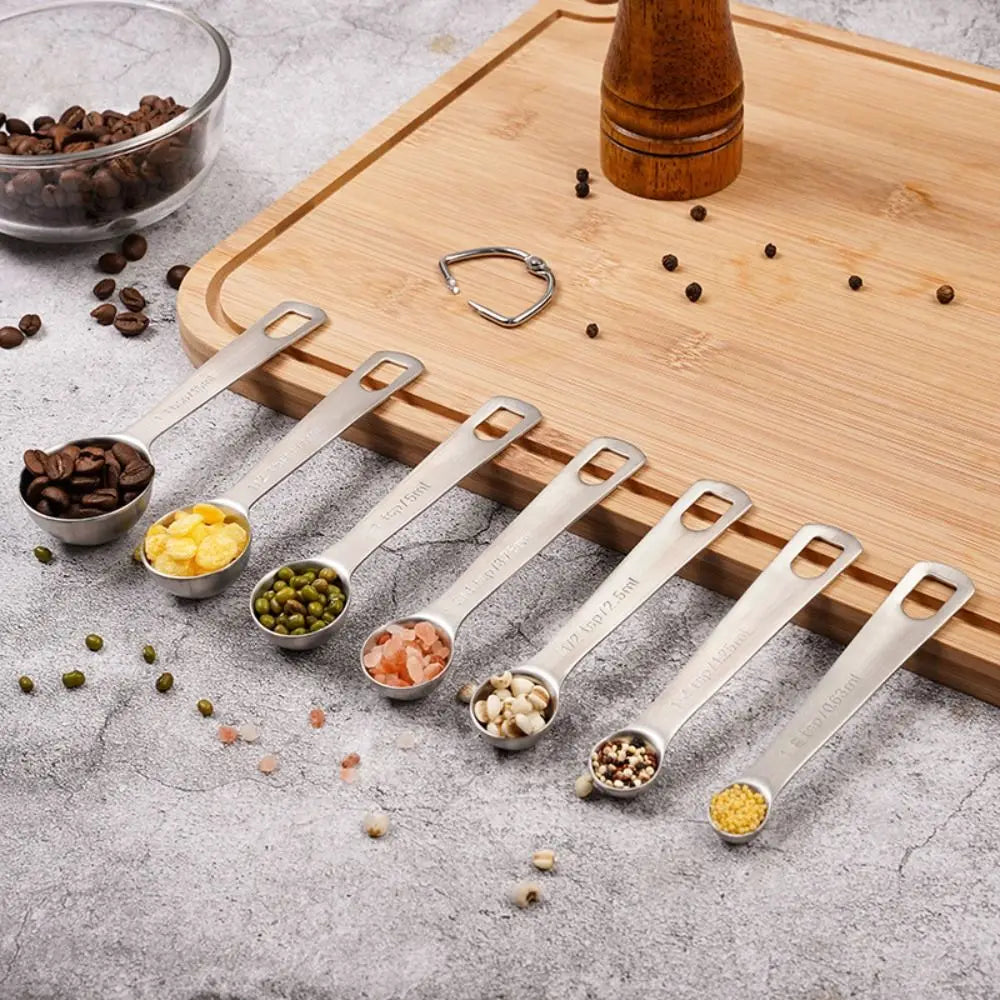 Set Cuillères Doseuses Inox 304 – 7 ou 11 Pièces Précises avec différents ingrédients disposés dans chaque cuillère