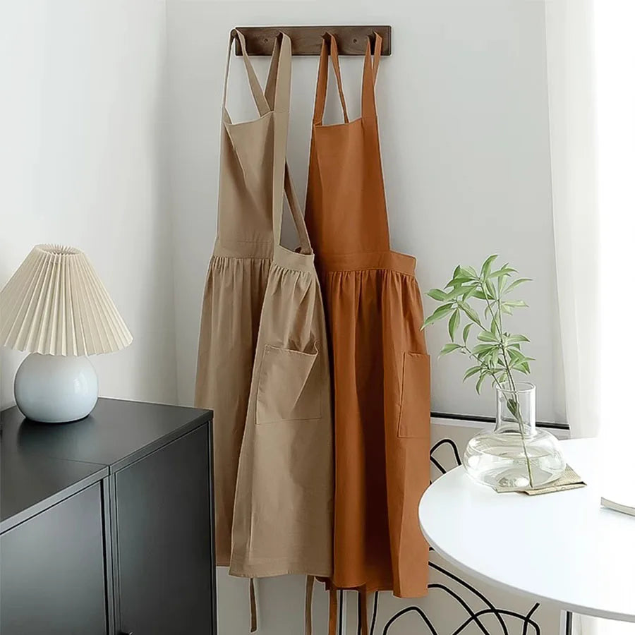 Tablier long imperméable femme – Élégant et confortable en beige et marron suspendus dans une cuisine moderne