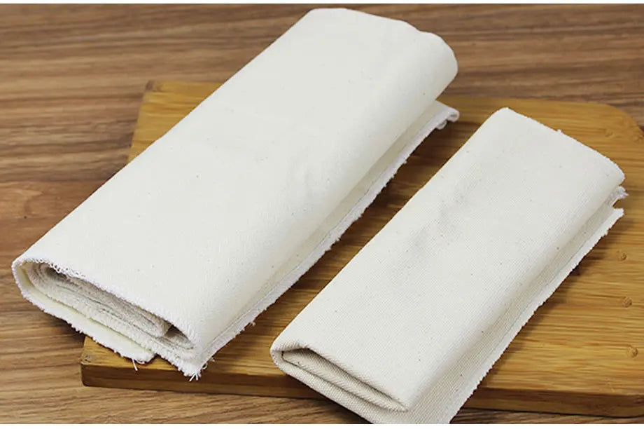 Tapis de Poussée Coton 100 % Pur pliés sur une planche en bois pour ustensiles de cuisine