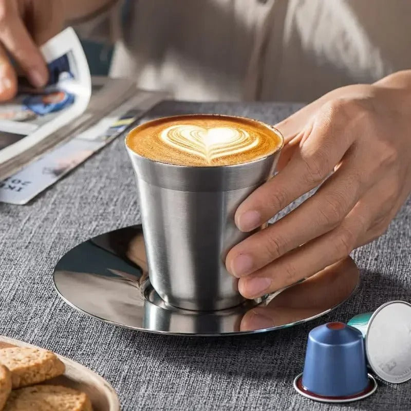 Tasse expresso inox double paroi avec un café crémeux et un sous-plat élégant