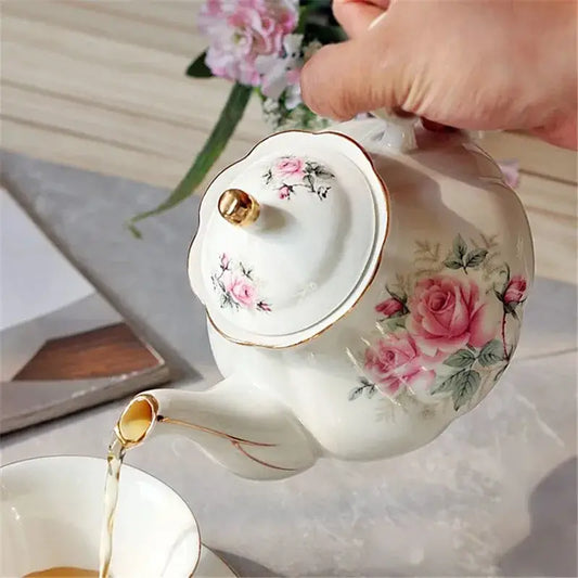 Théière et Tasse en Céramique avec motif de roses, en train de verser du thé d'un service élégant