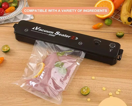 Machine sous vide alimentaire – Compacte et puissante. Scelle viande et agrumes sur plan de travail en bois
