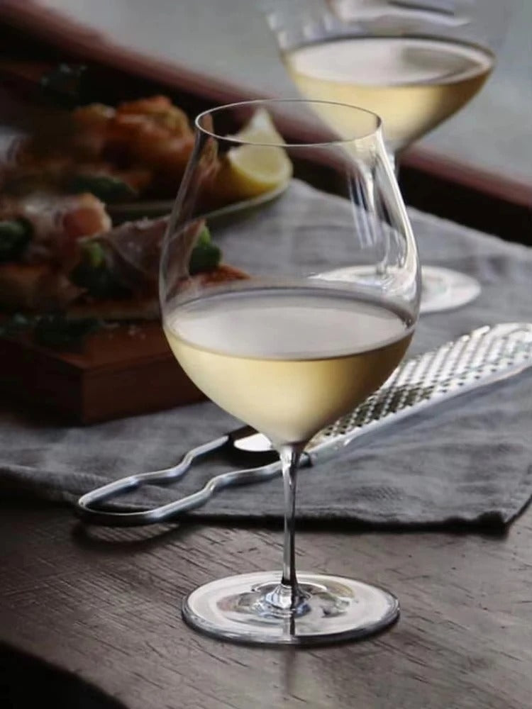 Verre à vin en cristal ultra-fin fait main 430 ml sur une table avec des plats appétissants en arrière-plan