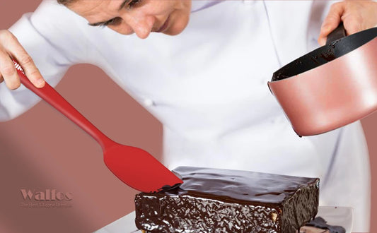 Spatules Silicone Pro Haute Température rouge utilisées pour étaler du glaçage sur un gâteau au chocolat