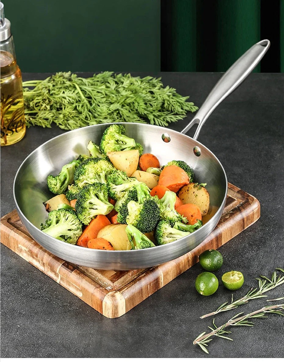 Wok Inox Multicouche Antiadhésif – 22-28 cm Tous Feux avec légumes sautés sur planche en bois par Ustensiles de chef