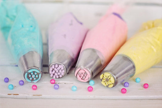 Poches à douille colorées remplies de crème pour décorer avec les 5 Outils Essentiels pour Réussir Vos Desserts Maison