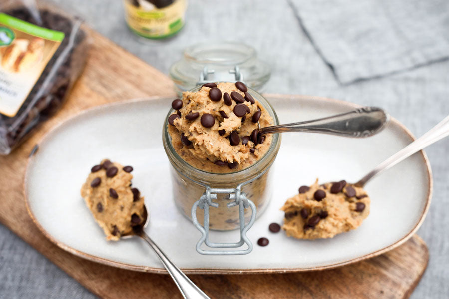 Pâte à Cookie Cru : 5 Recettes Saines, Rapides et Sans Cuisson servie dans un bocal avec des pépites de chocolat