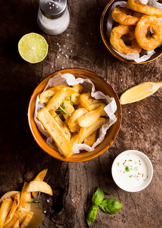 Recette Frites Maison Faciles : Croustillantes et Gourmandes servies avec des herbes et tranches de citron