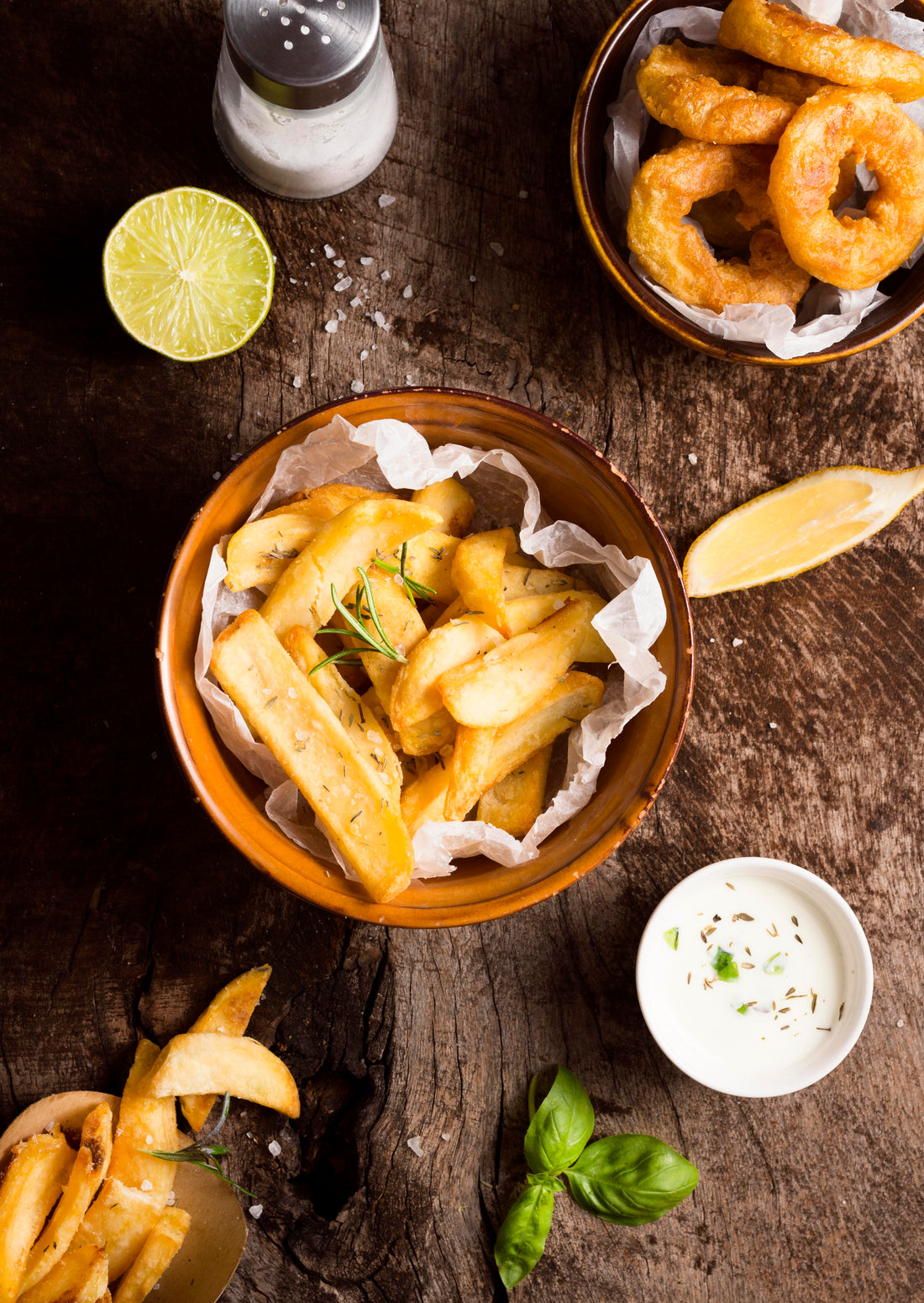 Recette Frites Maison Faciles : Croustillantes et Gourmandes servies avec des herbes et tranches de citron