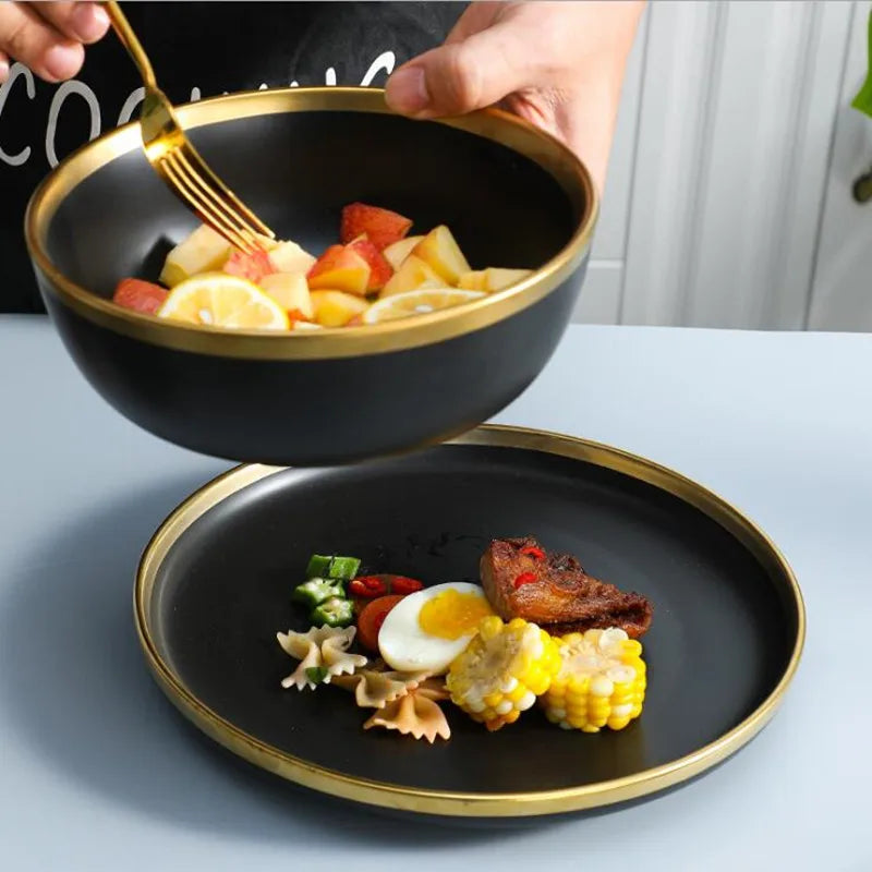 Assiettes en céramique noires bord doré – Service complet avec des fruits et légumes présentés à table