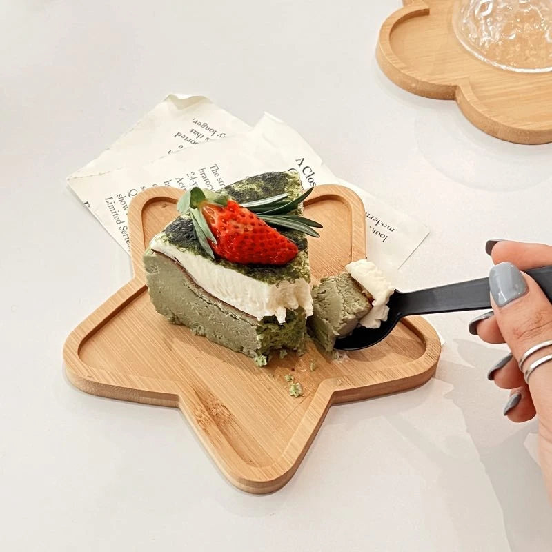 Gâteau matcha sur plateau étoile en bambou, main avec cuillère. Plateau Décoratif en Bambou – Élégance Naturelle Pratique.