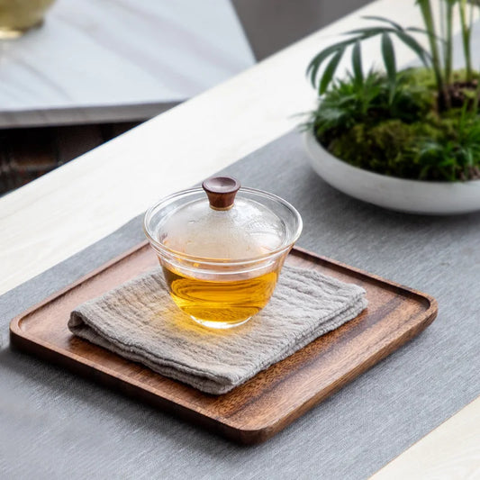 Plateau en Bois Noyer – Design Rétro et Pratique pour Cuisine. Plateau carré en noyer avec tasse de thé en verre sur serviette