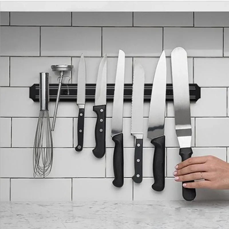 Barre Magnétique Couteaux Inox avec plusieurs couteaux en acier inoxydable et un fouet sur un mur de cuisine