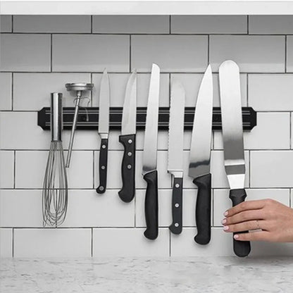 Barre Magnétique Couteaux Inox avec plusieurs couteaux en acier inoxydable et un fouet sur un mur de cuisine