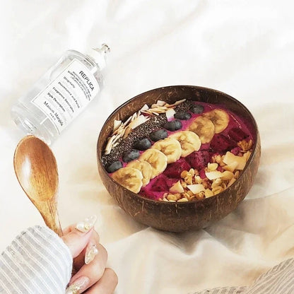 Bol en coquille de noix de coco rempli de smoothie aux fruits et décoré de bananes et de noix