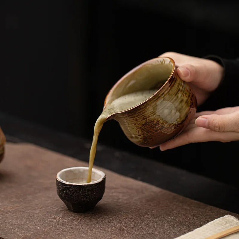 Bol Matcha en Céramique Japonais 280 ml avec une main versant du thé vert dans une petite tasse